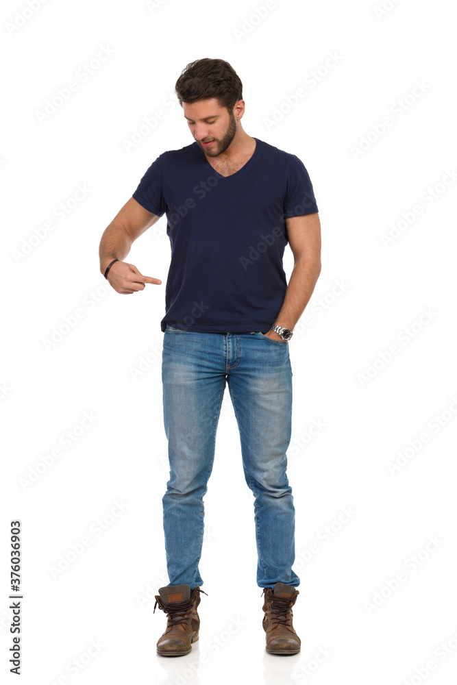 Young Man Is Standing And Pointing At His Waist And Looking Down Young Man Is Standing And Pointing At His Waist And Looking Down