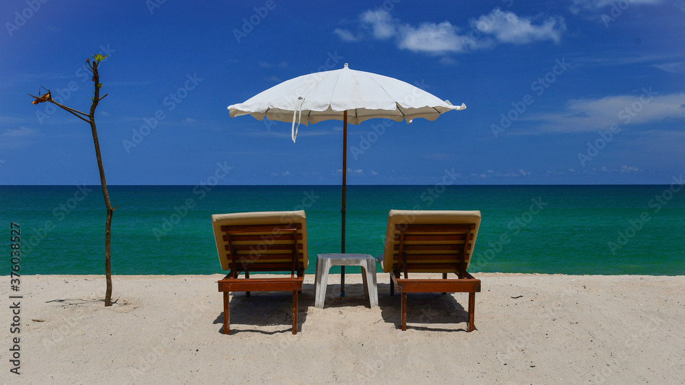 Tropical beach, sunloungers and white parasol
