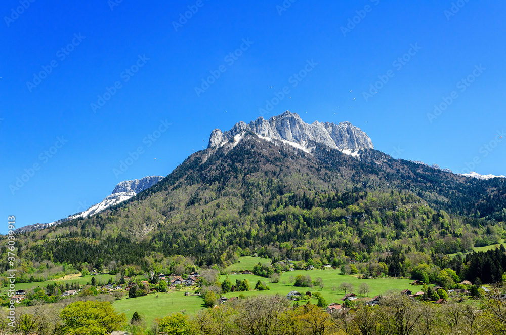 A mountain without a name in the Lake Annecy area and paratroopers using it for jumping and flying. At the foot of the mountain is the famous castle Menthon-Saint-Bernard