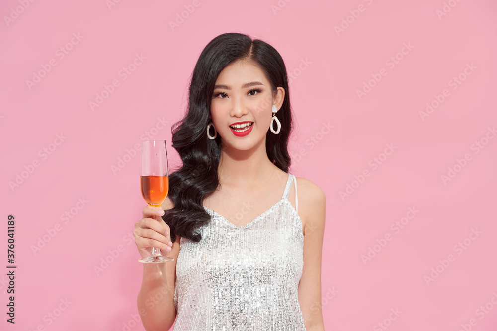 Happy fashion woman drinking champagne in a silver dress in party Happy fashion woman drinking champagne in a silver dress in party