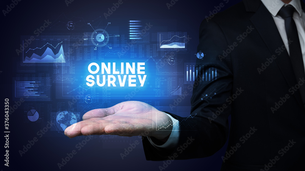 Hand of Businessman holding ONLINE SURVEY inscription, business success concept Hand of Businessman holding ONLINE SURVEY inscription, business success concept