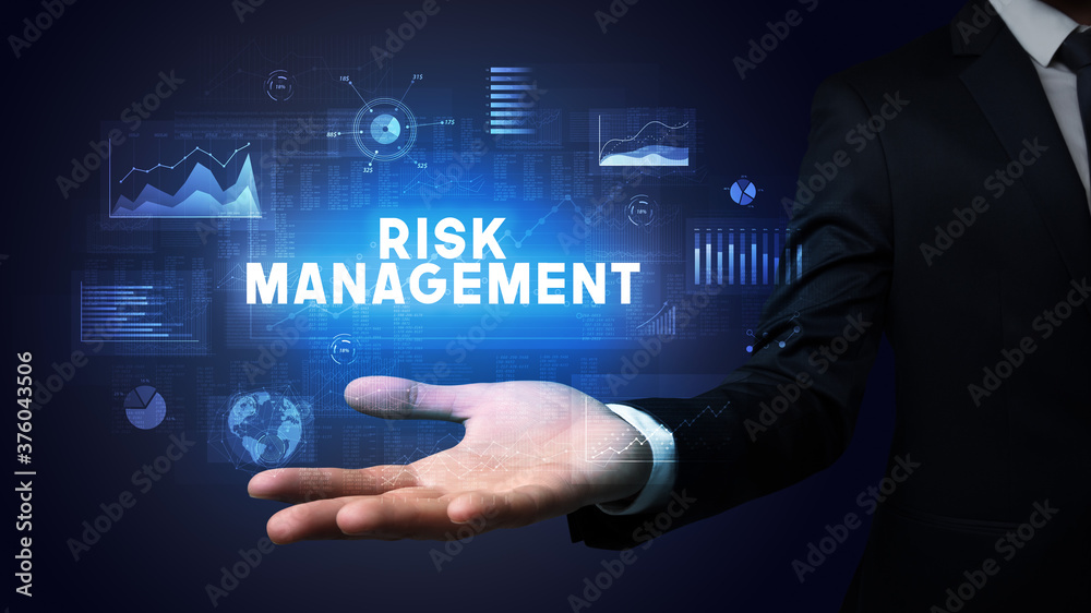Hand of Businessman holding RISK MANAGEMENT inscription, business success concept Hand of Businessman holding RISK MANAGEMENT inscription, business success concept