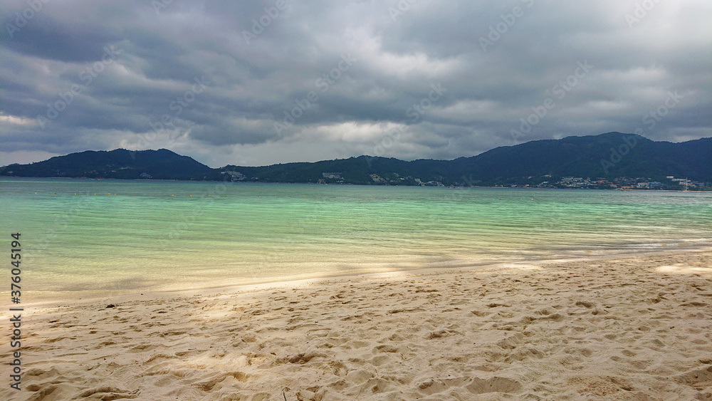 Storm over the mountains near Patong city in Phuket Island in Thailand. Beautiful view on the azure sea and golden sand.