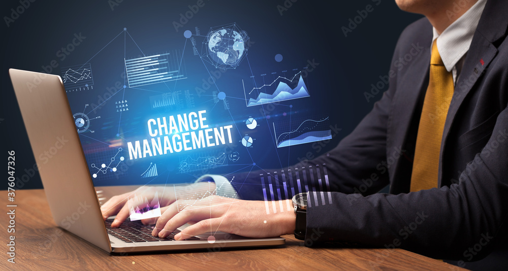Businessman working on laptop with CHANGE MANAGEMENT inscription, new business concept Businessman working on laptop with CHANGE MANAGEMENT inscription, new business concept