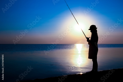 A Happy child fisherman fishing by the sea on nature silhouette travel