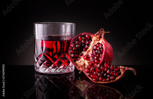 Glass of pomegranate juice with fresh fruits. Pomegranate juice in a wine glass.