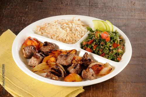 Carne acebolada com arroz e tabule photo