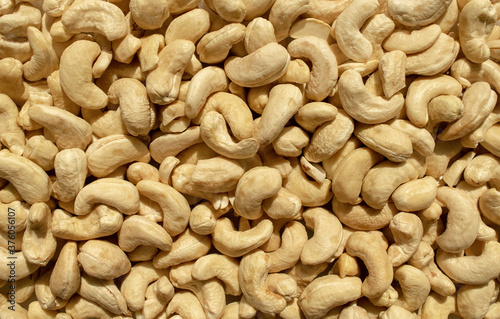 Background made of fresh plain cashew nuts. Healthy snack and food. Raw cashew backdrop. Top view.