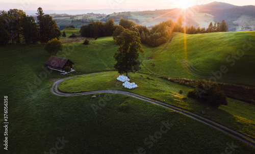 Aerial photography green grass sunrise Switzerland hills mountains farm © travel.n.think