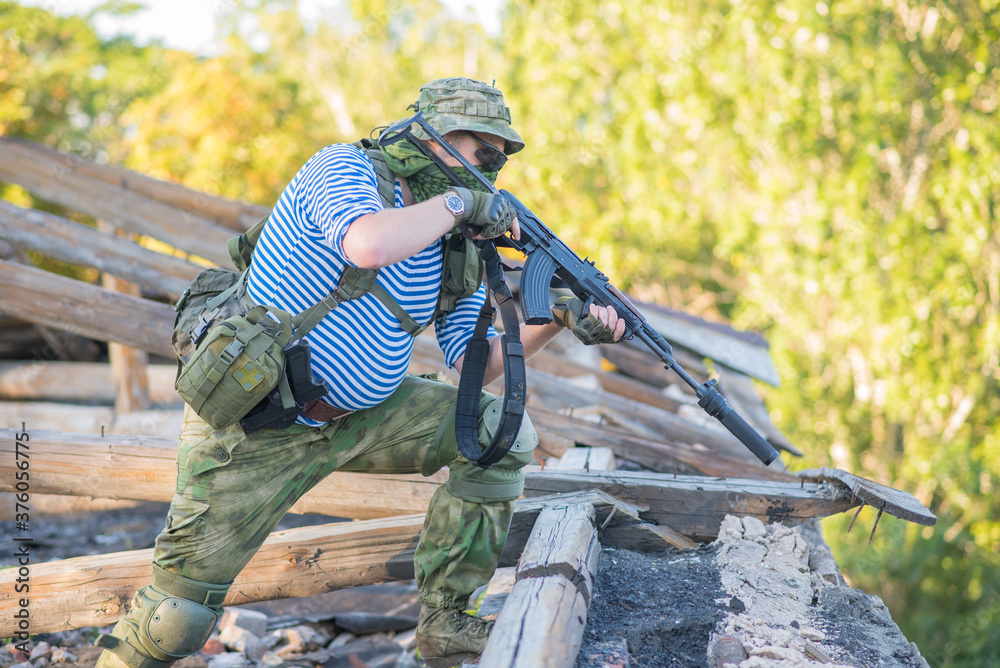 Fototapeta premium The airsoft player holds the defense, takes aim at the enemy