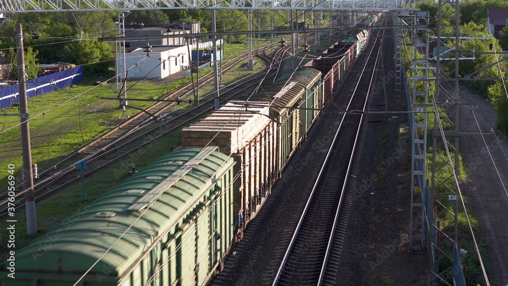 Freight train carries cargo. View of the train from above. Rail transport for intercity trade.