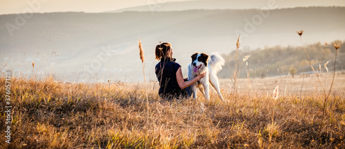Photography woman with dog relaxing in autumn landscape