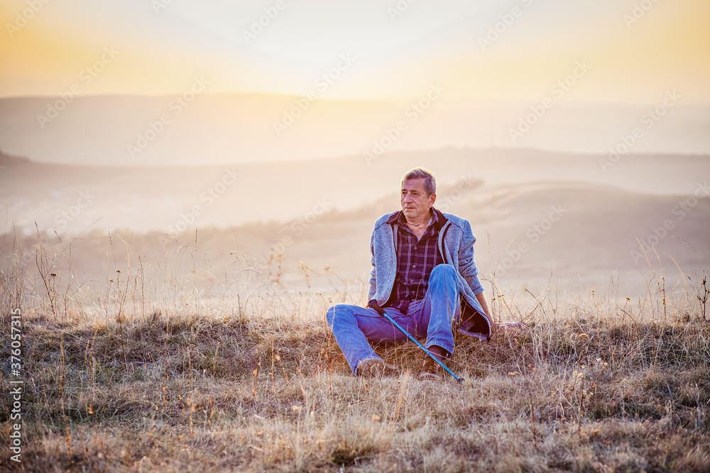 active senior man relaxing in autumn landscape after trekking active senior man relaxing in autumn landscape after trekking
