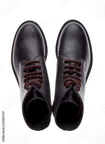 Black mountain boots made of durable leather, lace-up, with a massive sole, isolated on a white background with a shadow. Top view.
