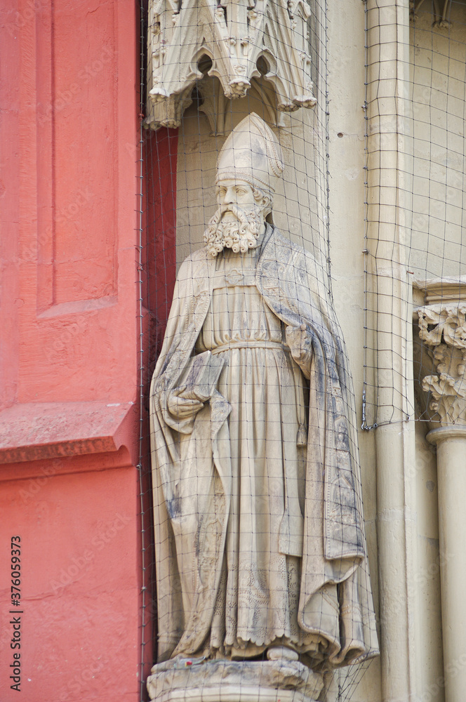 Ancient wall sculpture of a monk at the main facade of Mary chapel in historical downtown of Wurzburg, Germany