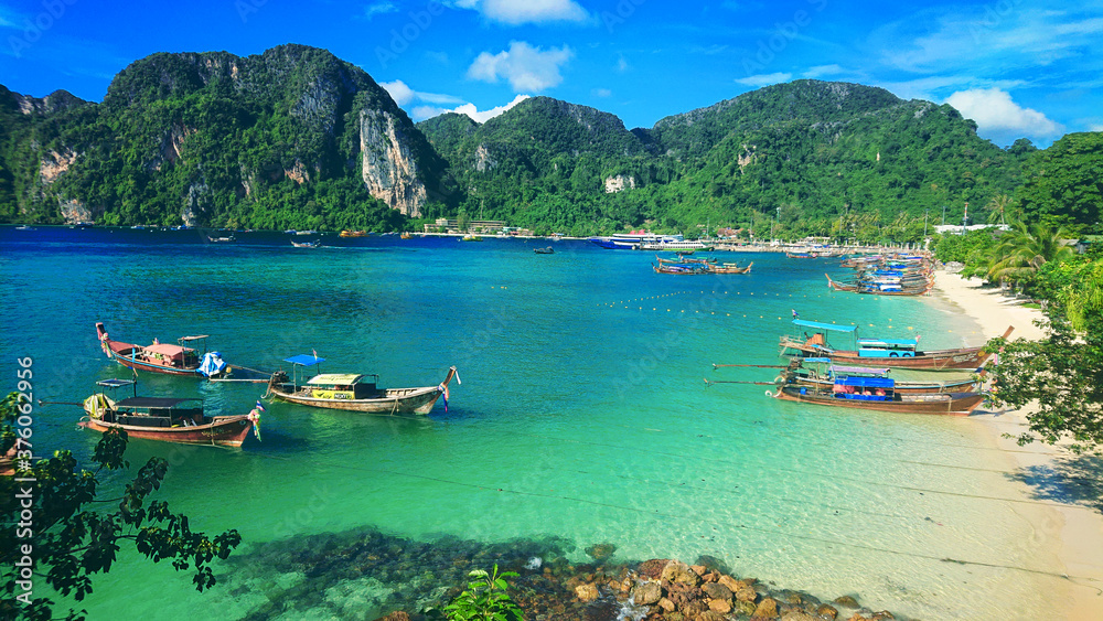 Beautiful view on the mountains and sea in the Phi Phi Don island near Phuket Island in Thailand. In the distance you can golden sand, azure water, thai boats and jungle in the mountains.