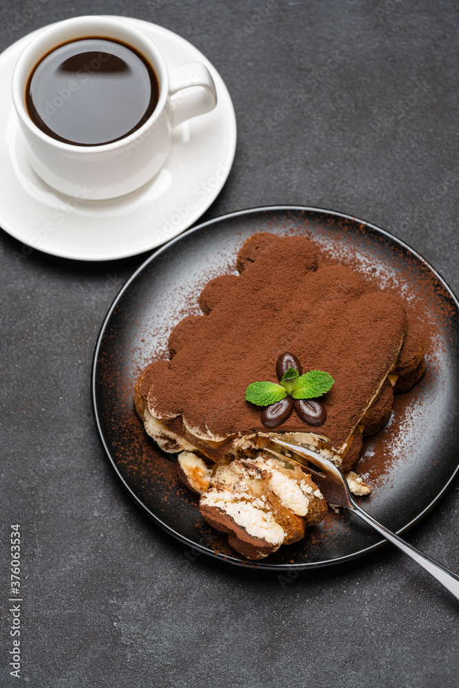 portion of Classic tiramisu dessert and cup of fresh espresso coffee on concrete background