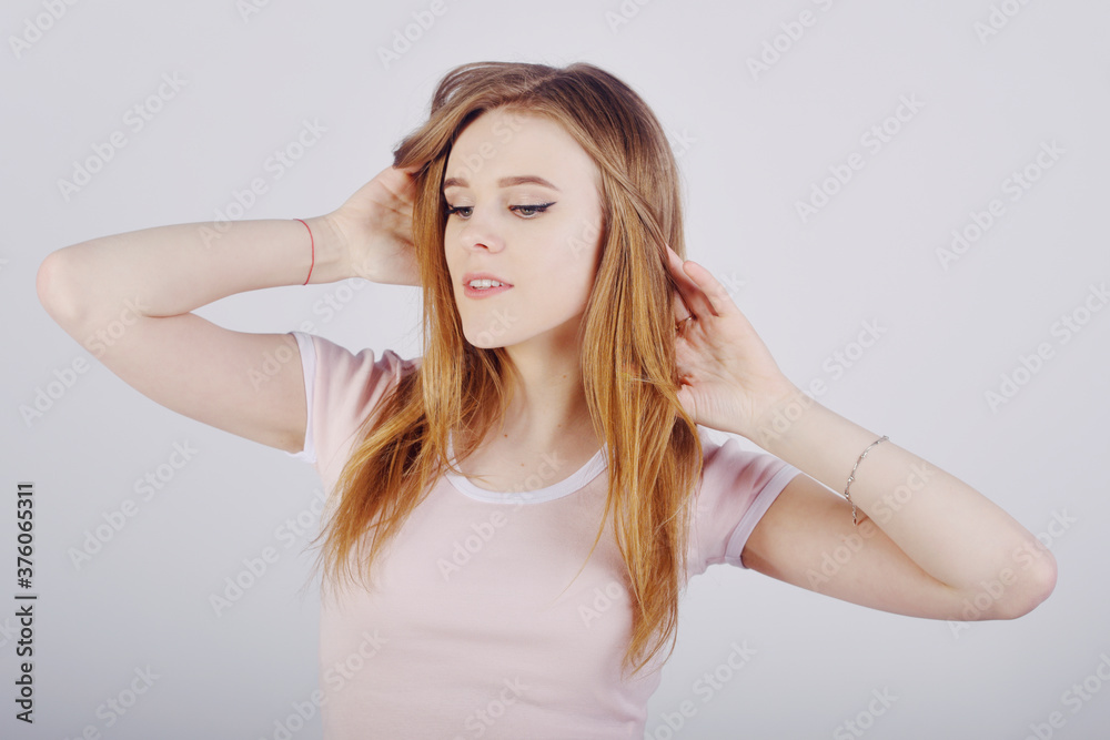 The blonde with gorgeous hair, the girl touches her hair with her hands, care.