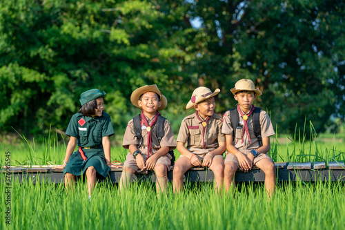 America boy scouts in uniform sitting in green field on a sunny day while,Summer camp. photo