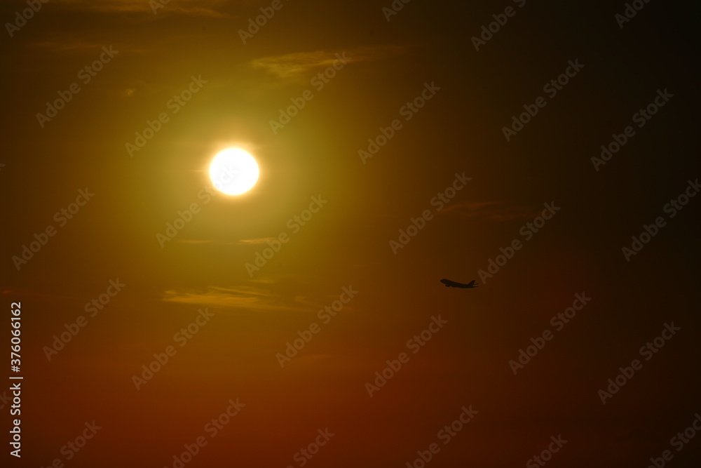 太陽に向かって上昇する飛行機