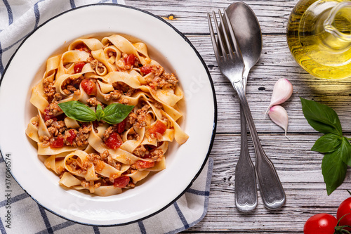 Traditional italian pasta bolognese on a white plate on a wooden background