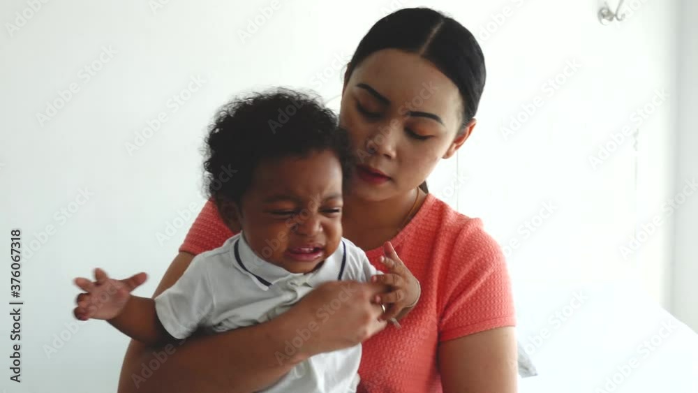 Young asian woman mother comforting and hugging her crying little toddler boy son at home, parenthood lifestyle concept Young asian woman mother comforting and hugging her crying little toddler boy son at home, parenthood lifestyle concept