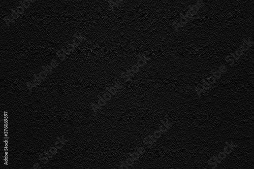Black wall of the building. Rough plaster surface. Abstract background.