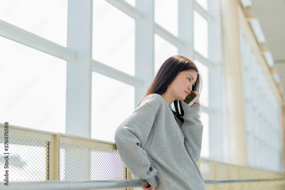 Fototapeta premium Unhappy worried young asian woman talking on phone with serious expression.