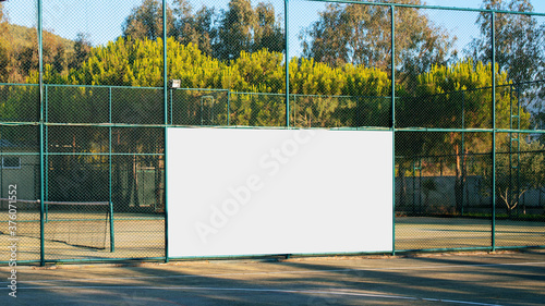 Obraz na plátně empty advertising white banner with mockup on iron fence on sport playground