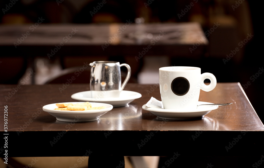 Fresh hot coffee on wooden table in cafe interior and free space for your decoration.