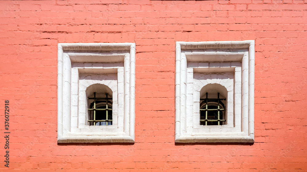 An old red brick wall with two Windows. An old red brick wall with two Windows.