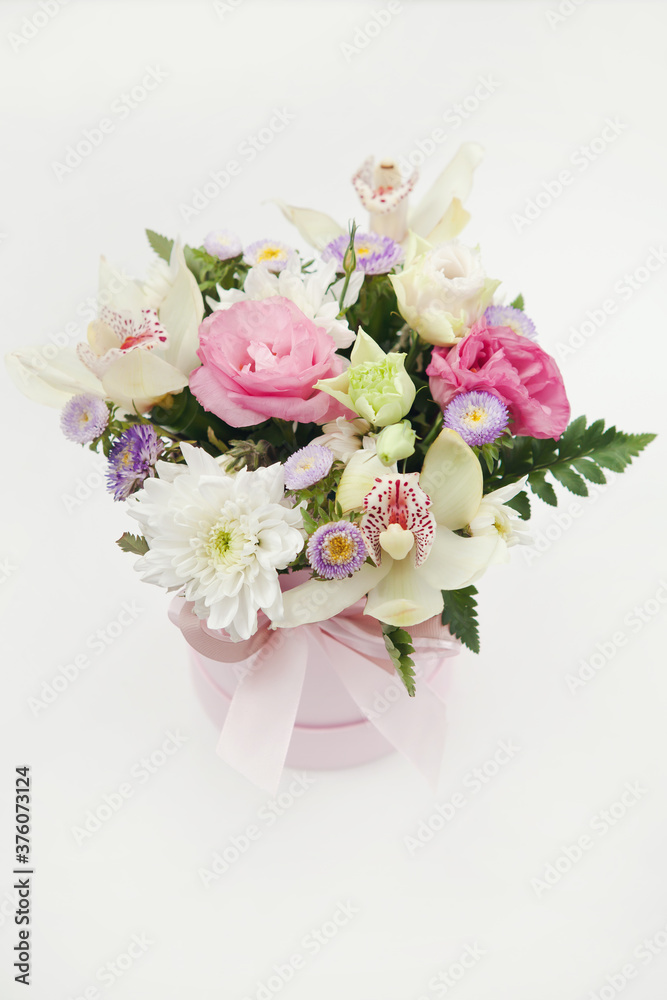Romantic bouquet of delicate flowers in pink paper gift box