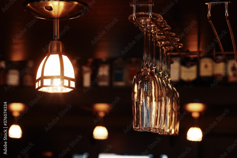 Bright lamp and wine glasses hang in the cafe
