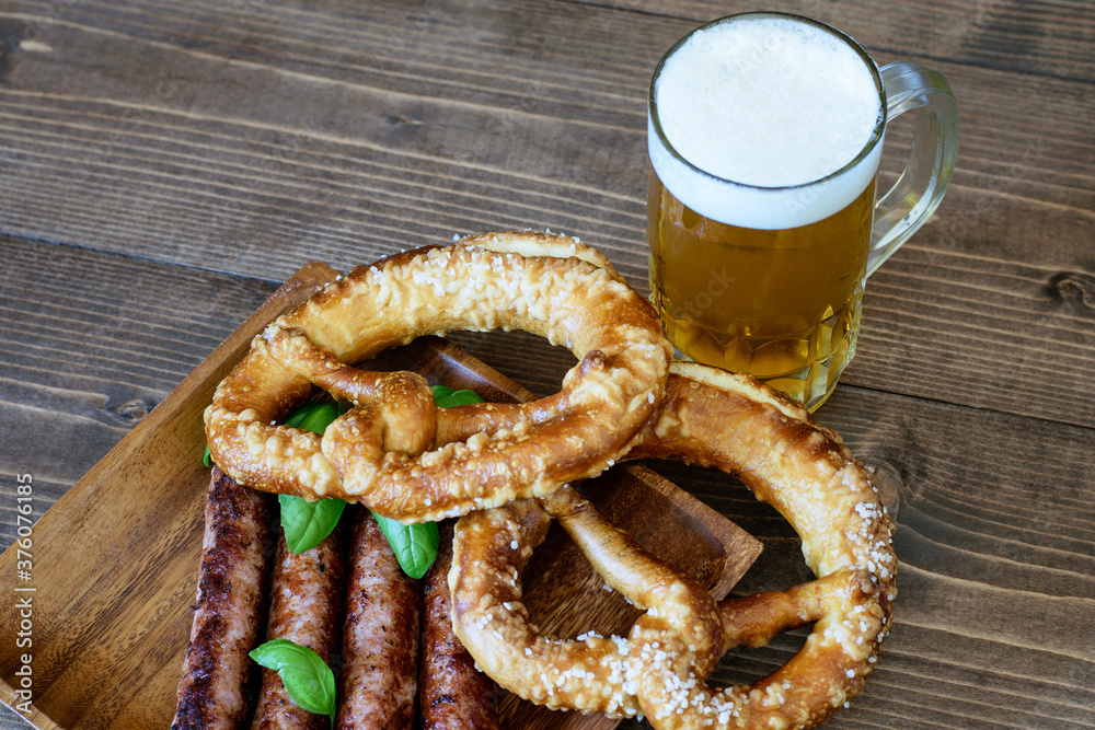 Light beer served with cretzels and sausages on the wood, nice choice for October fest. Light beer served with cretzels and sausages on the wood, nice choice for October fest.