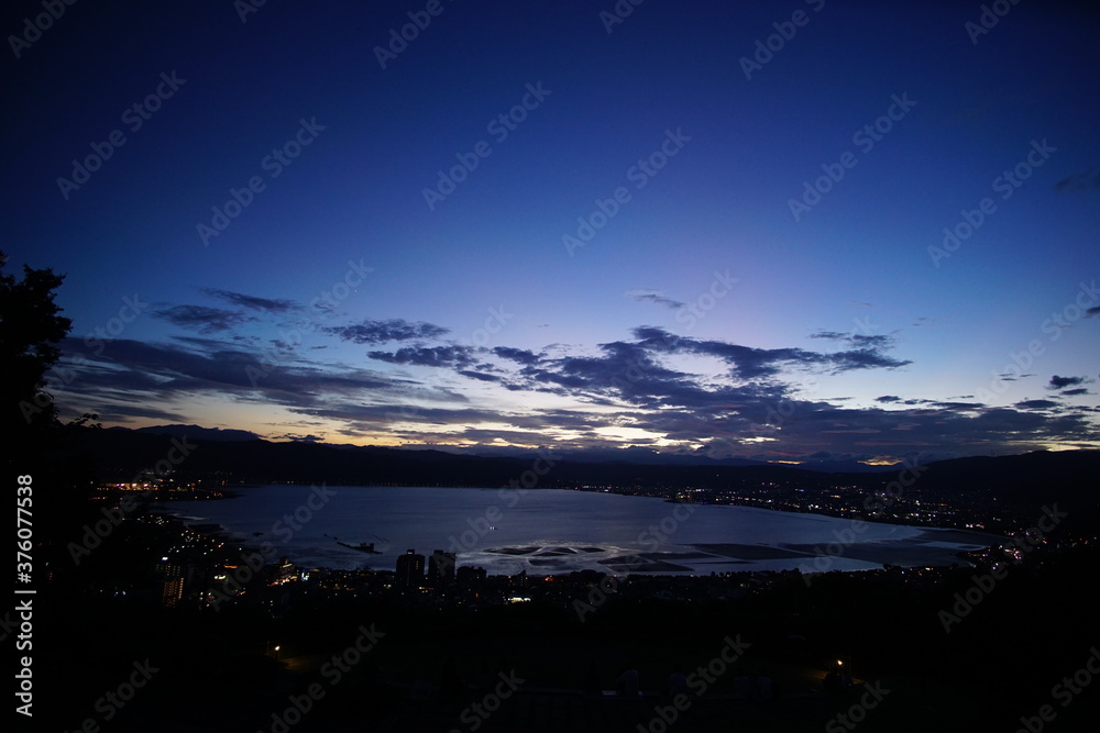 A wide shot looking out over the Lake and the city in Japan during a summer sunset.