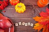 Greeting card with Autumn text. Composition with pumpkin, autumn leaves and red pears. Cozy autumn mood concept.