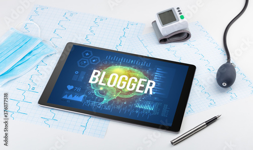Tablet pc and medical tools with BLOGGER inscription, social distancing concept