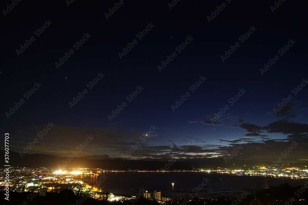 A wide shot looking out over the Lake and the city in Japan during a summer sunset. A wide shot looking out over the Lake and the city in Japan during a summer sunset.