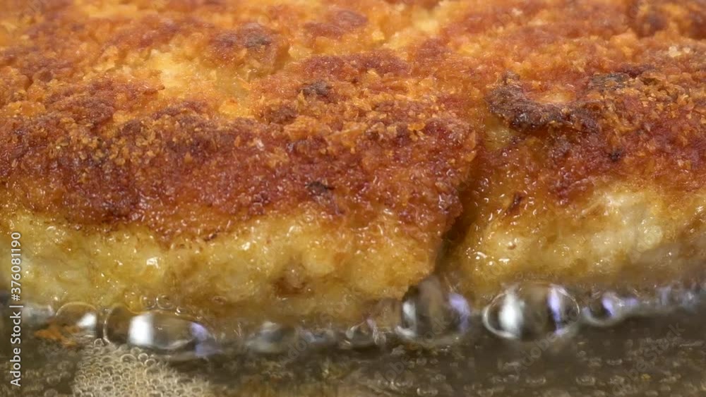 Close-up of fried juicy cutlets in breadcrumbs in a pan. Appetizing food. Bubbles of boiling oil. Macro photography. Close-up of fried juicy cutlets in breadcrumbs in a pan. Appetizing food. Bubbles of boiling oil. Macro photography.