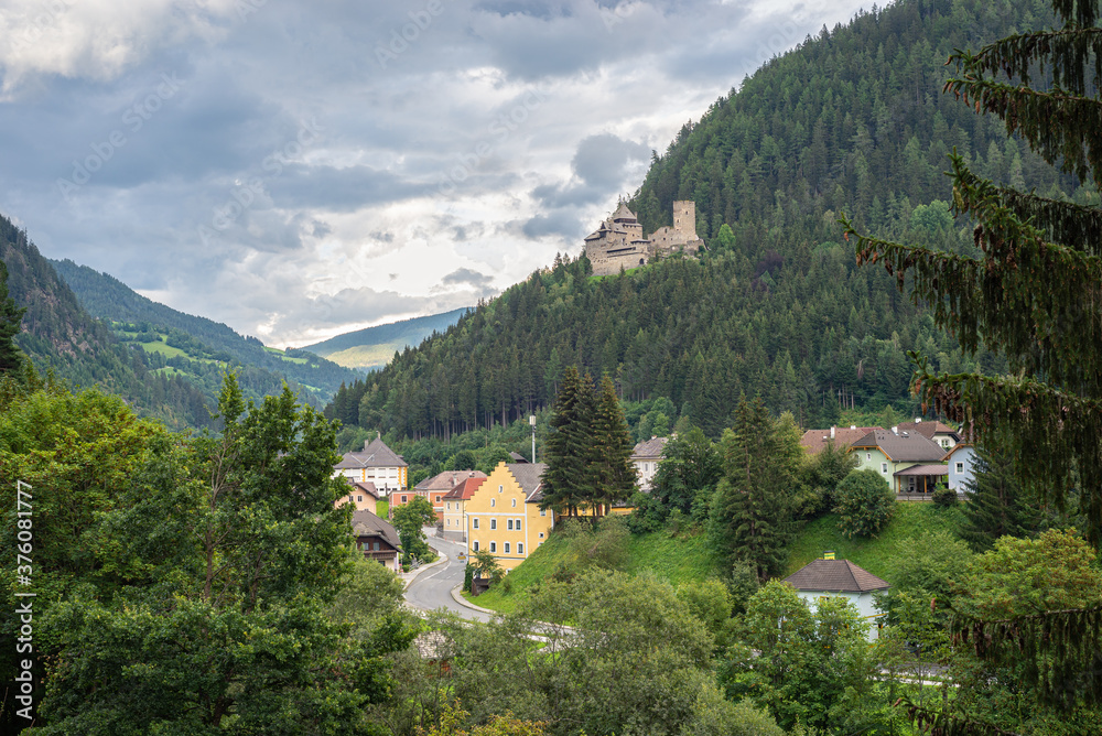 Scenic view of a valley with the small town of Ramingstein, Austria. Historic castle (burg) Finstergrun is located on a mountain slope above the town.