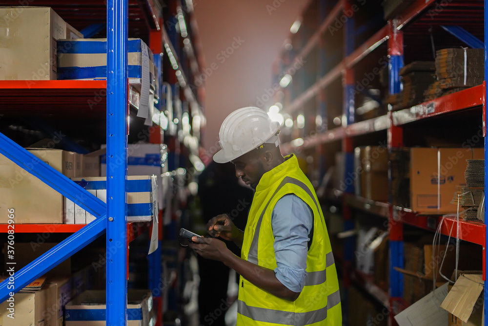 Male warehouse worker standing with barcode scanner