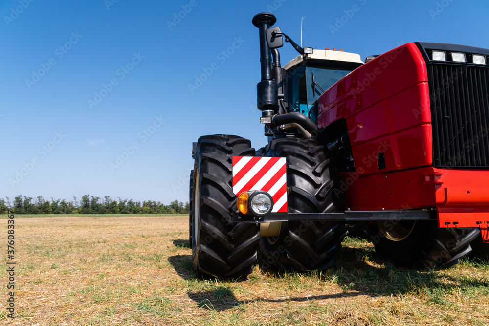 Obraz premium Red tractor on a agricultural field 