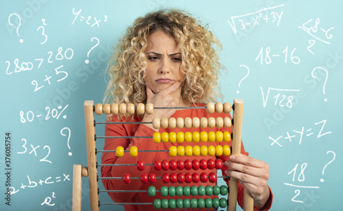Canvas Print Girl with abacus is confused about the sum . cyan background