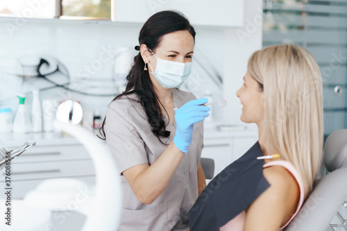 Female Dentist examine and discussing with happy patient about treatment