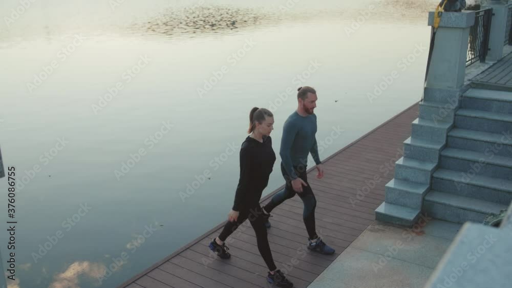 Young man and woman doing exercise at outdoor near lake workout happy sportswear active young sport runner fitness cardio summer slow motion Young man and woman doing exercise at outdoor near lake workout happy sportswear active young sport runner fitness cardio summer slow motion