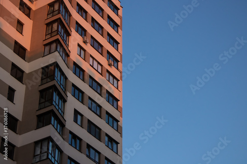 Facade of a modern light building on a blue sky background © Лилия Люцко