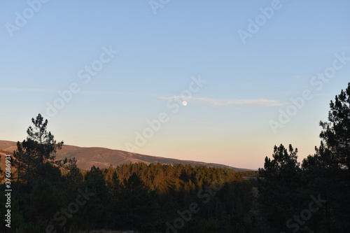 Landscape of a mountain with full moon by day