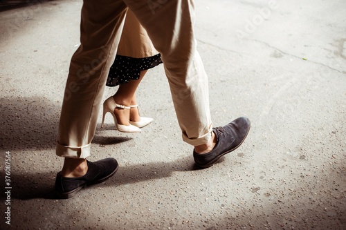 A man and a woman walk down the street on a sunny day