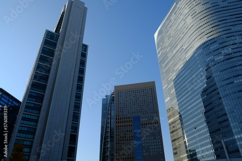 青空の中の都会のビルたち © Michio