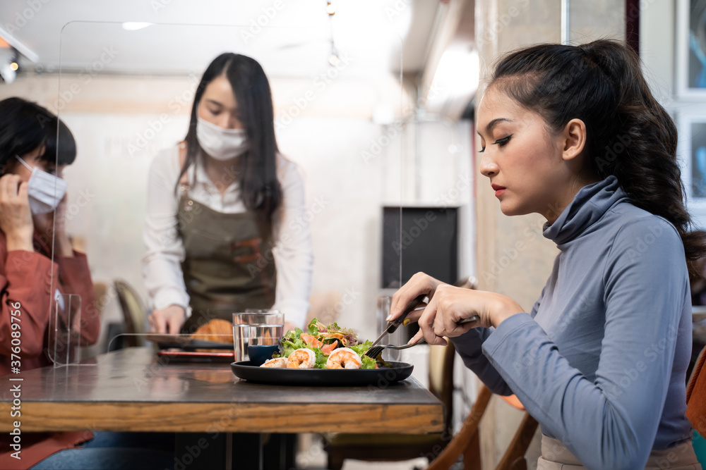 New normal customer dine in restaurant. Waitress with mask serve food. New normal customer dine in restaurant. Waitress with mask serve food.